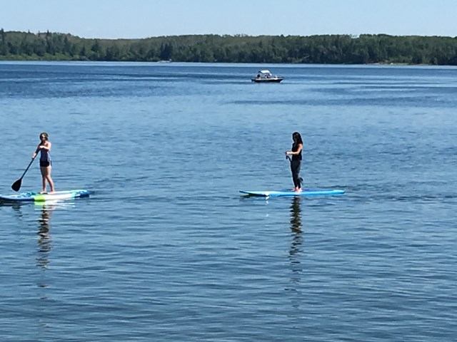 Two people on stand up paddle boards in the lake.