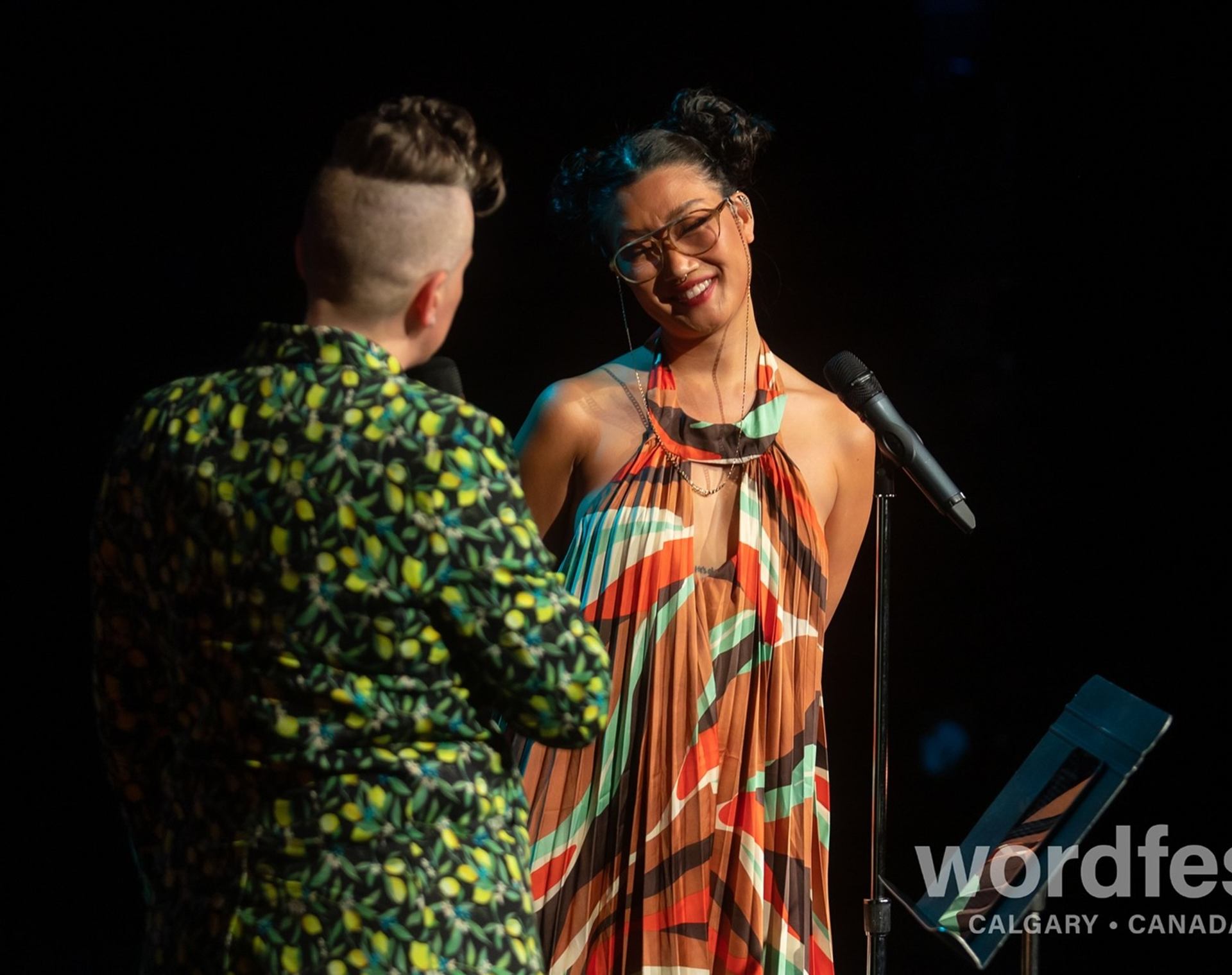 Performer smiling during a Wordfest live event on stage