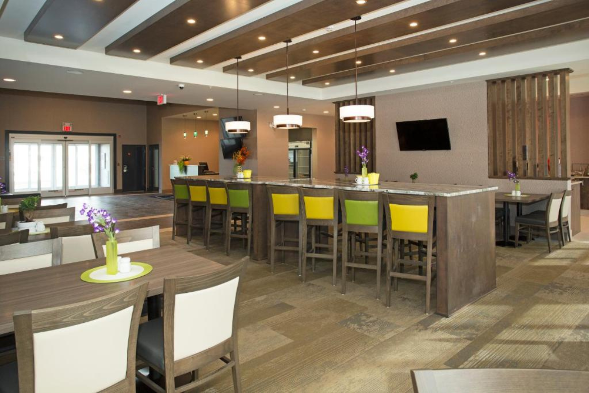 Hotel dining and lounge area with bar seating, tables, and modern lighting.