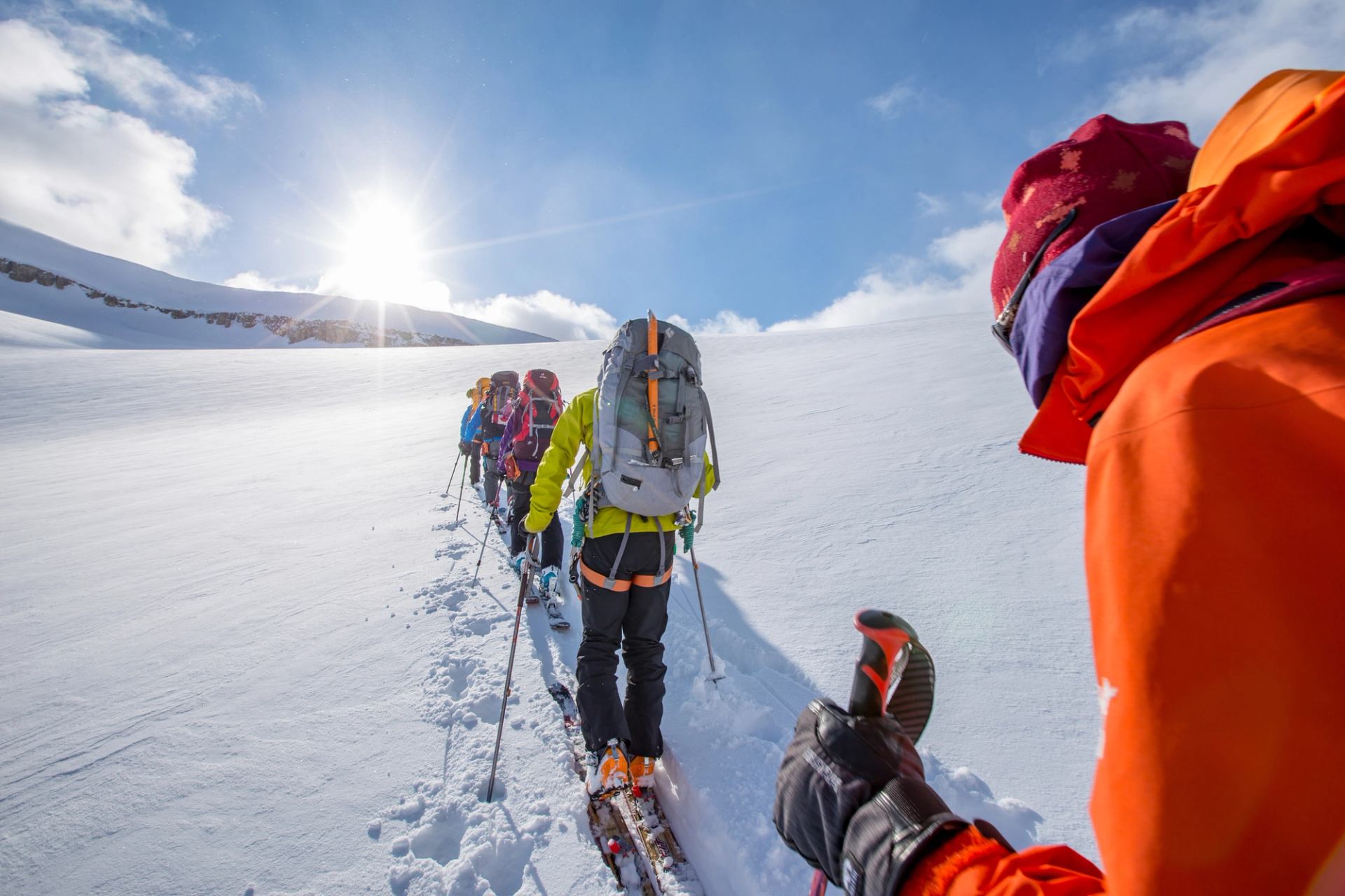 Group of people in single file, cross country skiing while in the backcountry