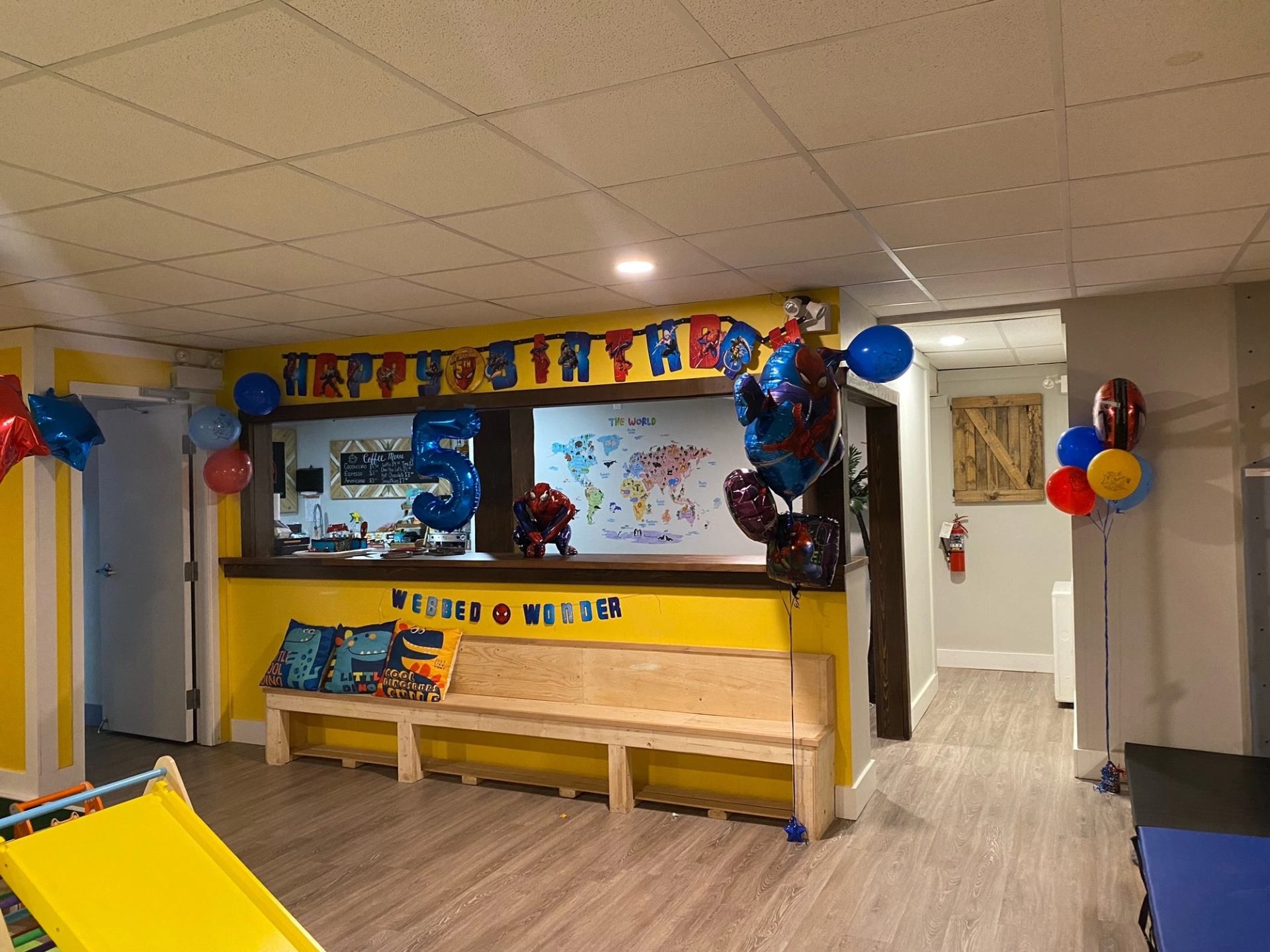 Birthday party room with colorful decor, balloons, and cartoon-themed banner.