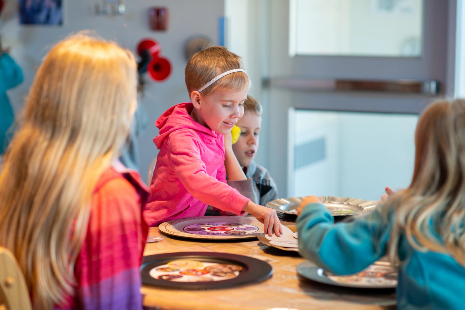 Kids sit around a table assembling colourful nature crafts during the event.