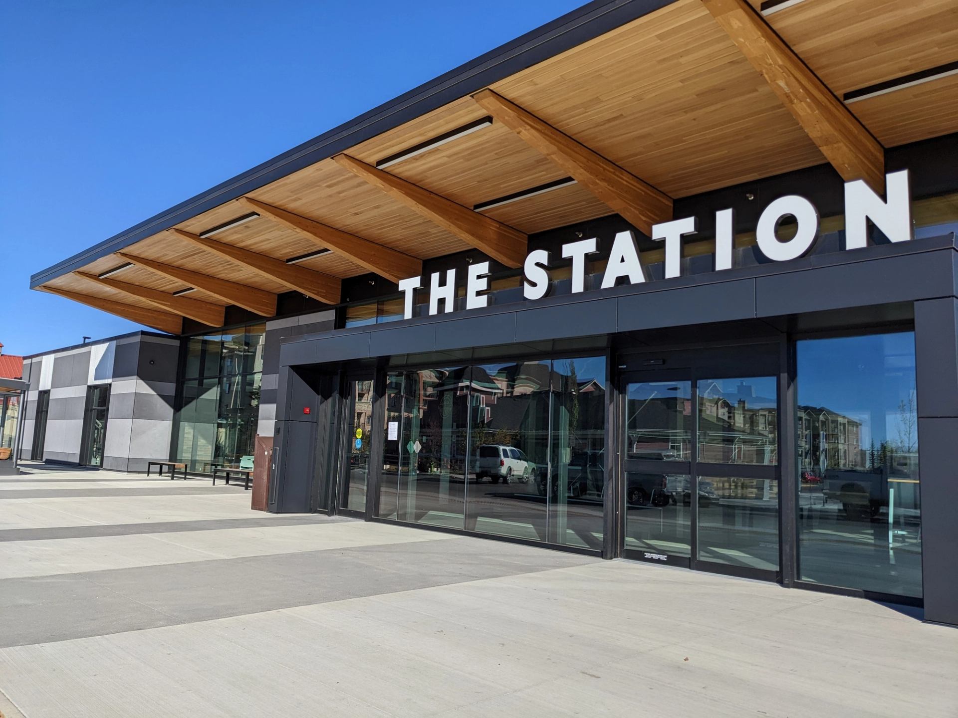 Exterior of The Station building with wood accents, large glass doors, and bold white lettering.