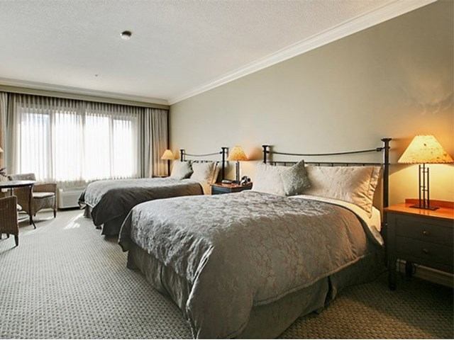 Hotel room at Park Place Inn with two beds, desk, and window.
