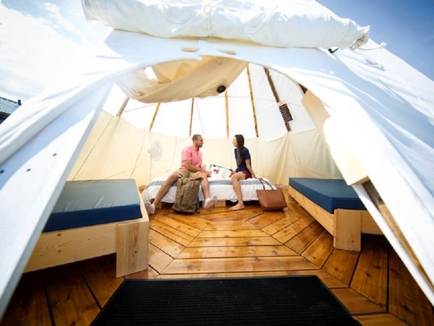 Two people inside a tipi camping