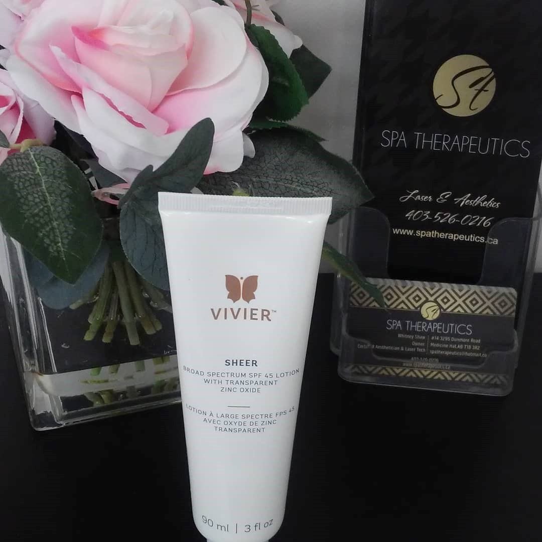 Vivier Sheer SPF lotion tube beside roses and Spa Therapeutics signage.