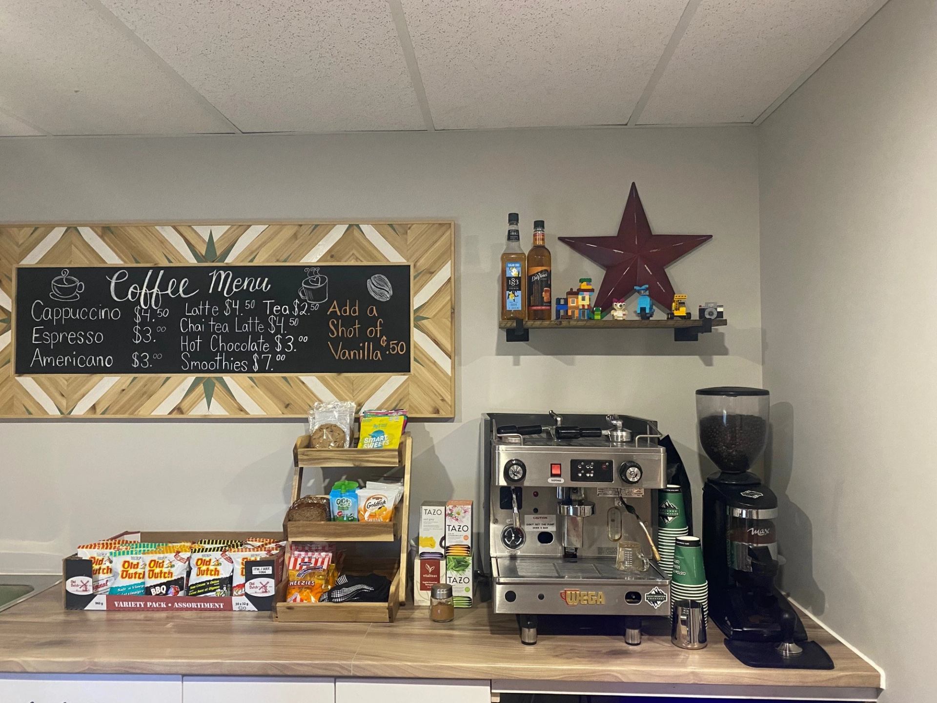 Cubz Play Cafe coffee station with menu, espresso machine, and flavor syrups.