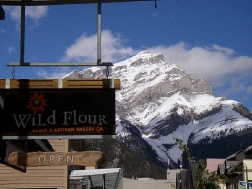 Wild Flour Bakery sign with snow-capped mountain in the background.