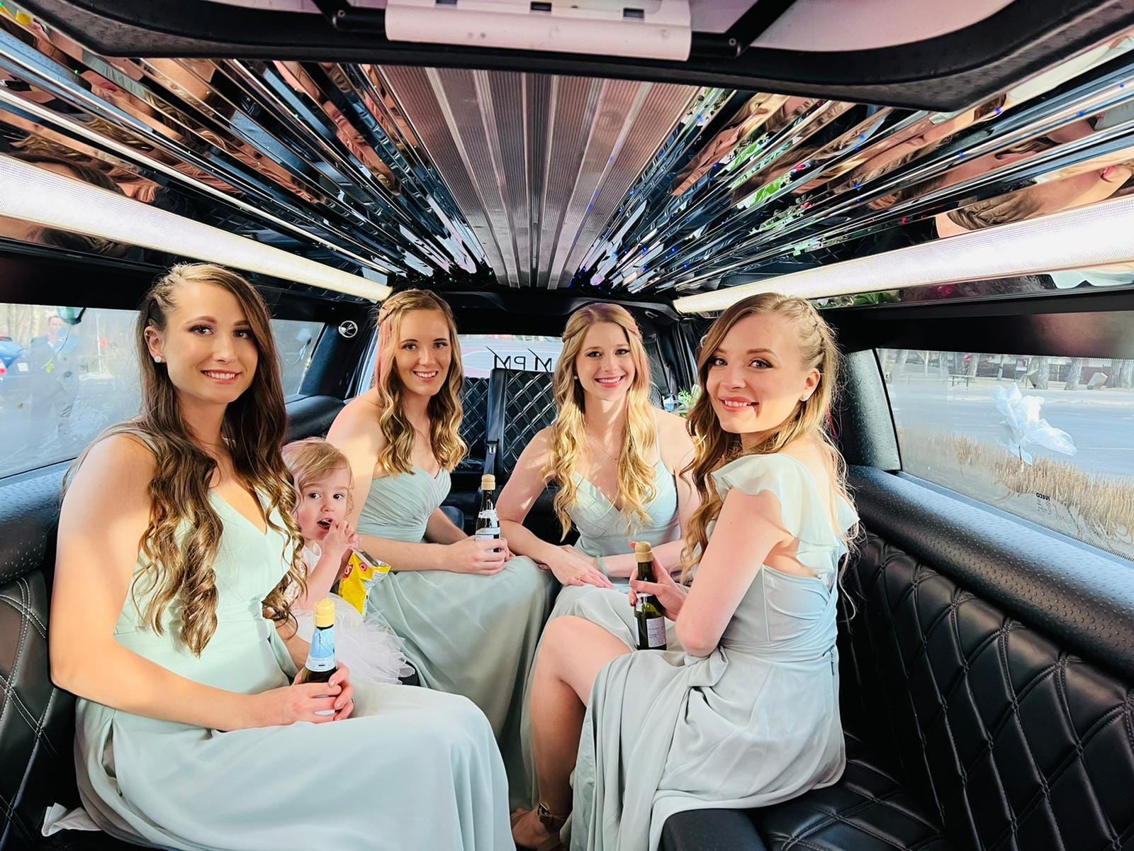 People in formal wear inside a sleek, reflective party limo.