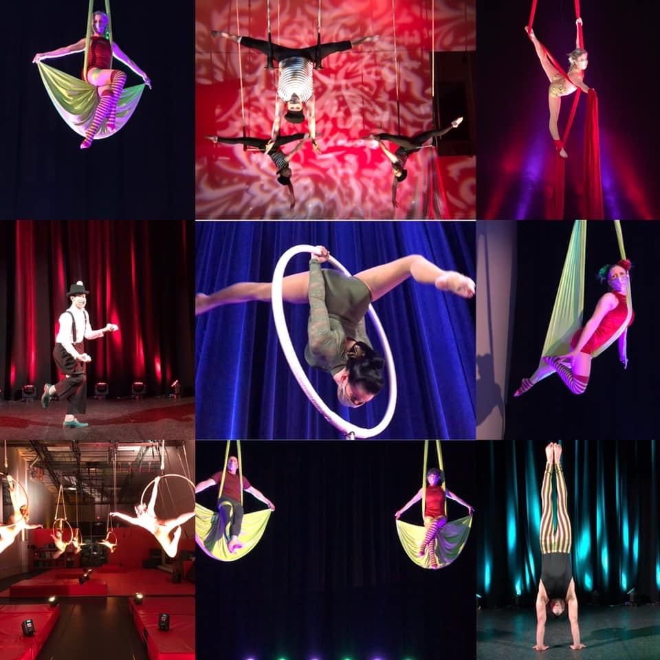 Circus performers on stage using fabric and aerial hoops, with coloured lighting and backdrop.