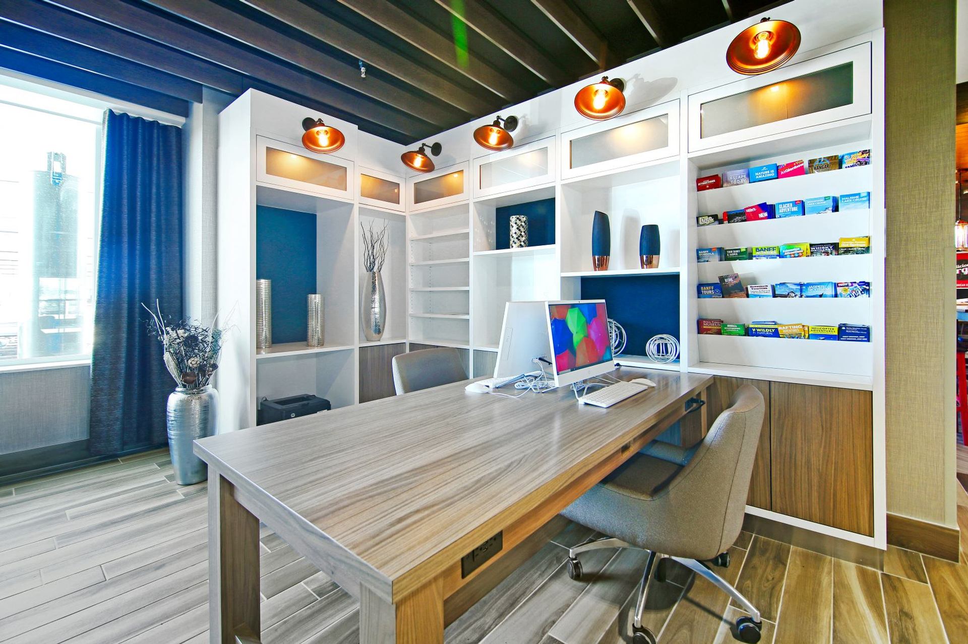 Desk with computer and shelves in a bright business center area