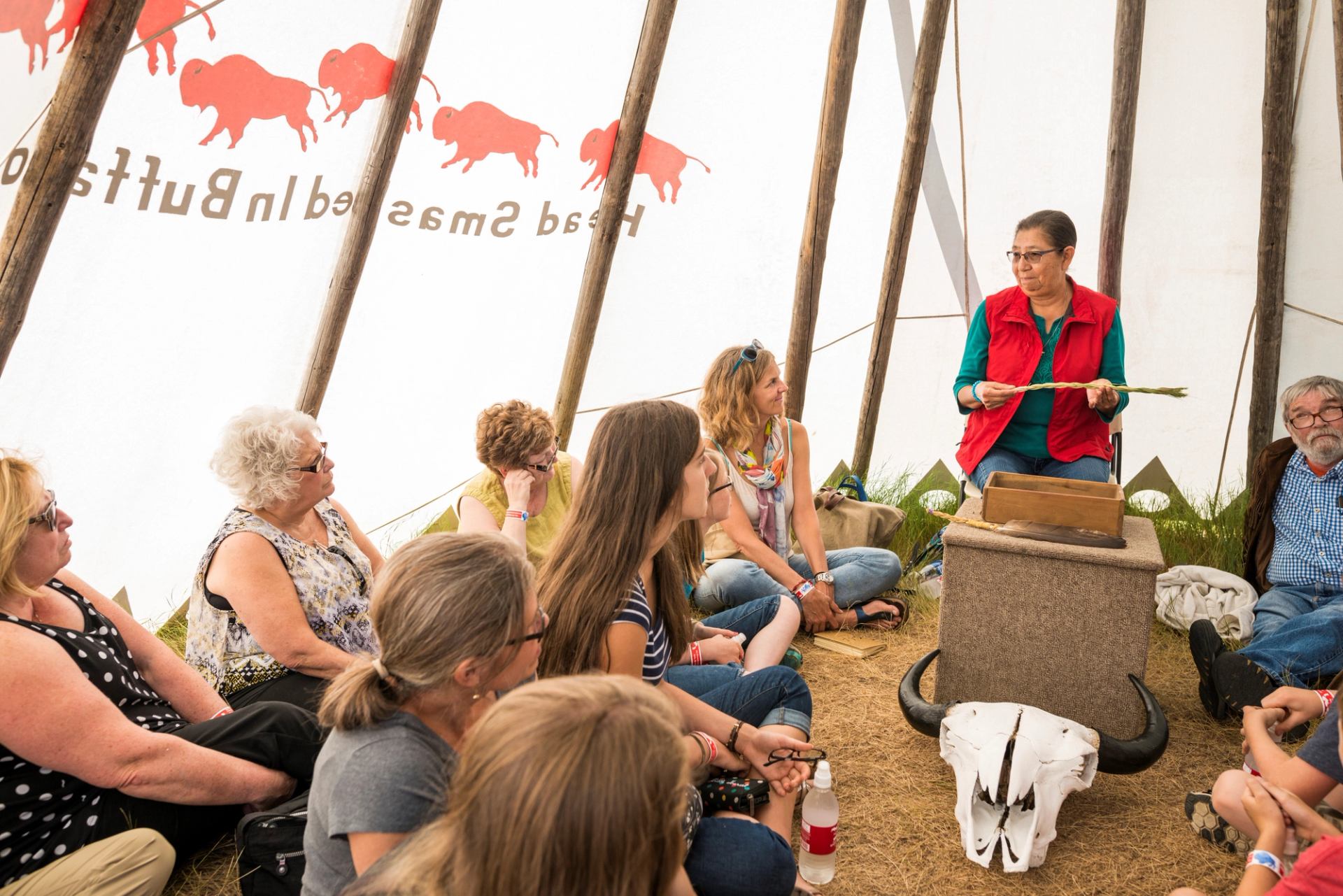 Group inside a tipi listening to an indigenous presentation at Head-Smashed-In Buffalo Jump.