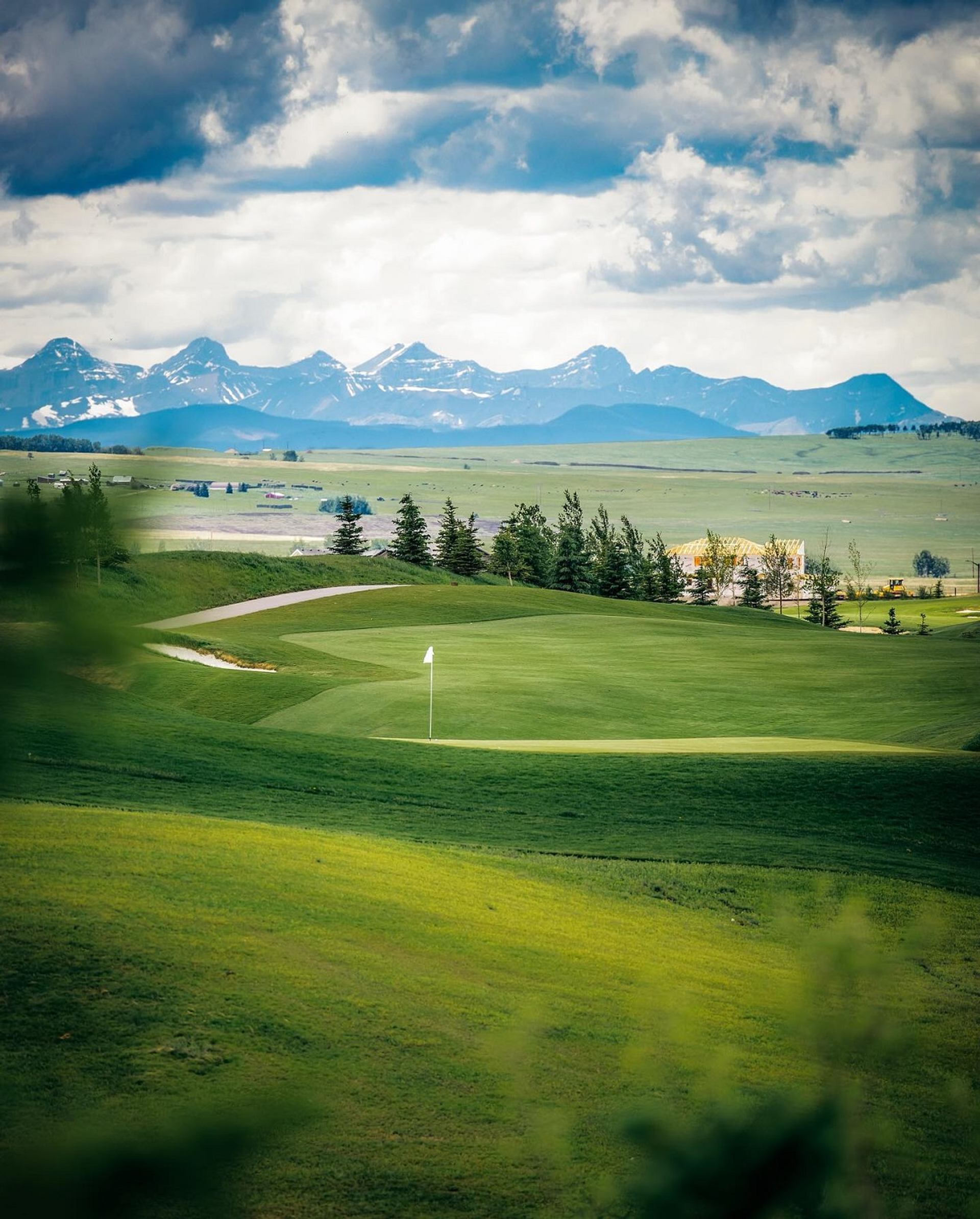 Lush fairway at Mickelson National Golf Club with mountain views in the distance.