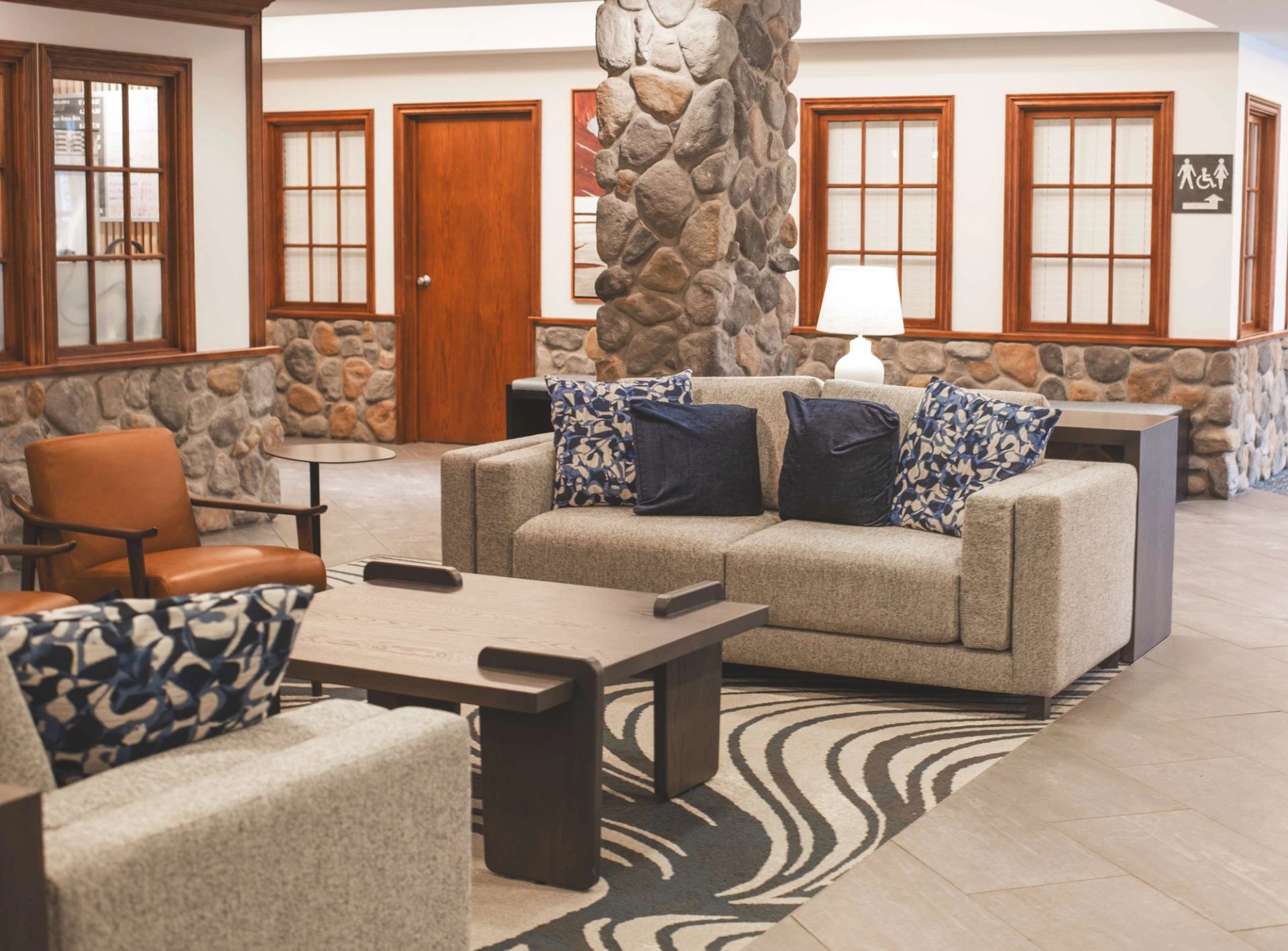 Cozy lobby with stone walls, plush seating, and warm lighting.