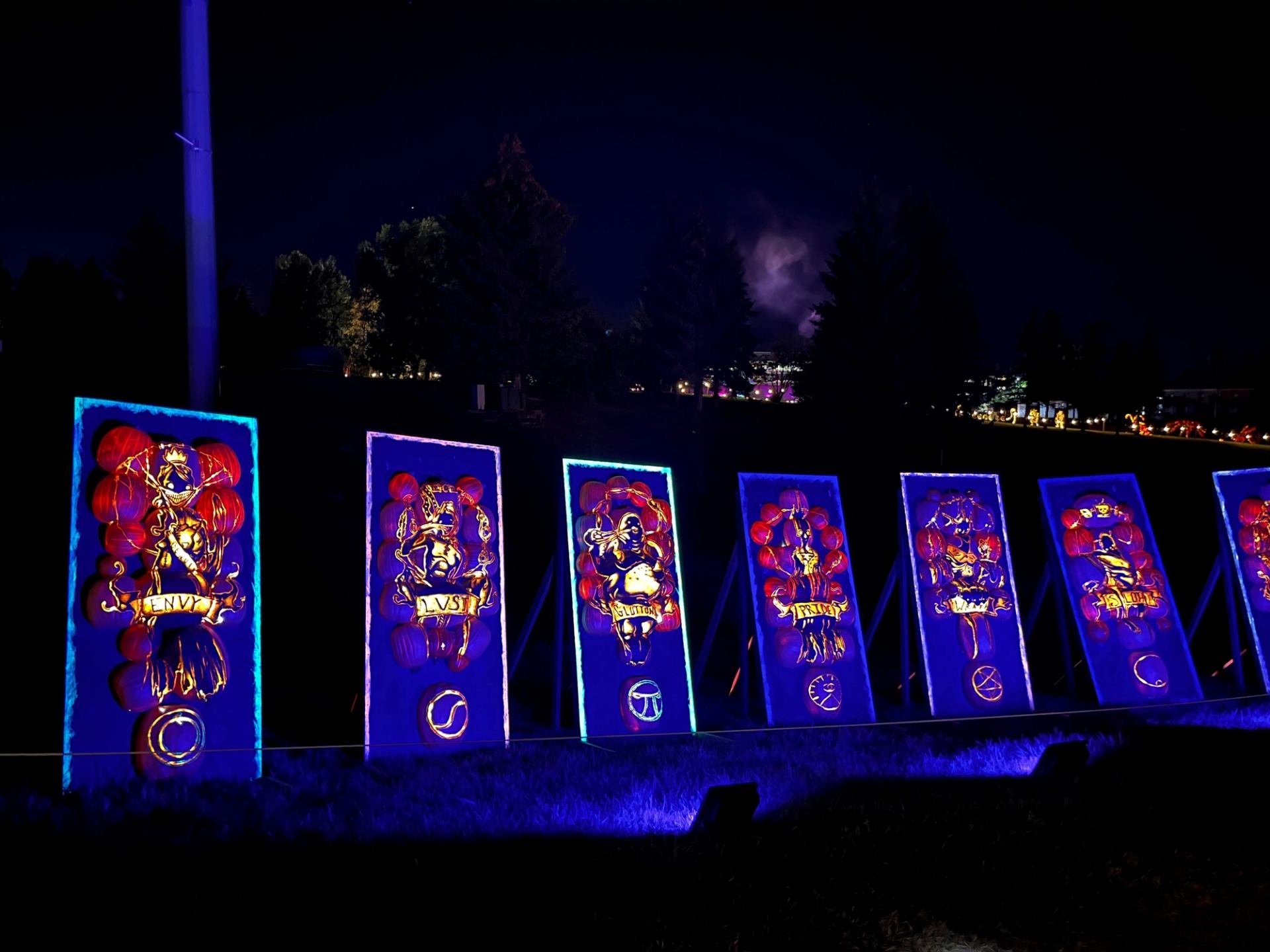 Vibrant illuminated art panels glowing blue in a nighttime outdoor display.