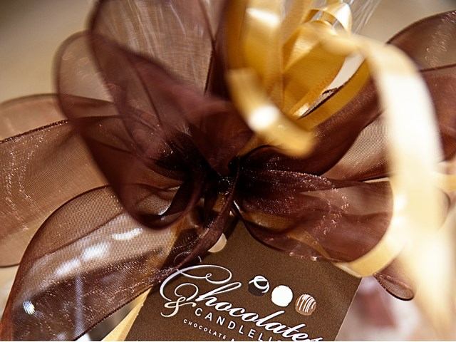 Elegant ribbon with tag reading “Chocolates & Candlelight,” featuring chocolates and candles.