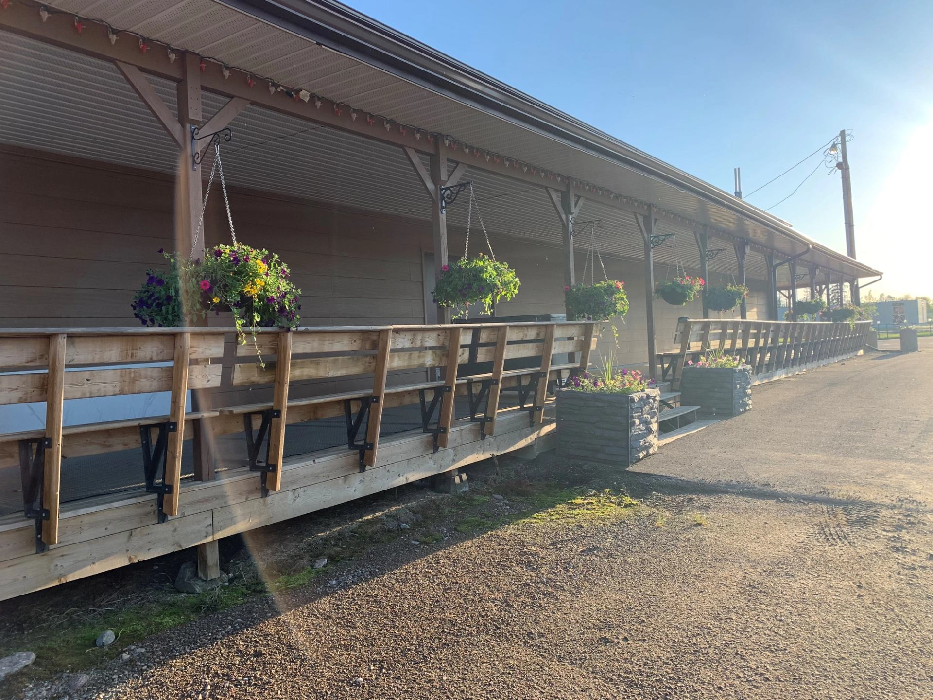 Wooden deck with hanging flower baskets outside Zama Community Hall