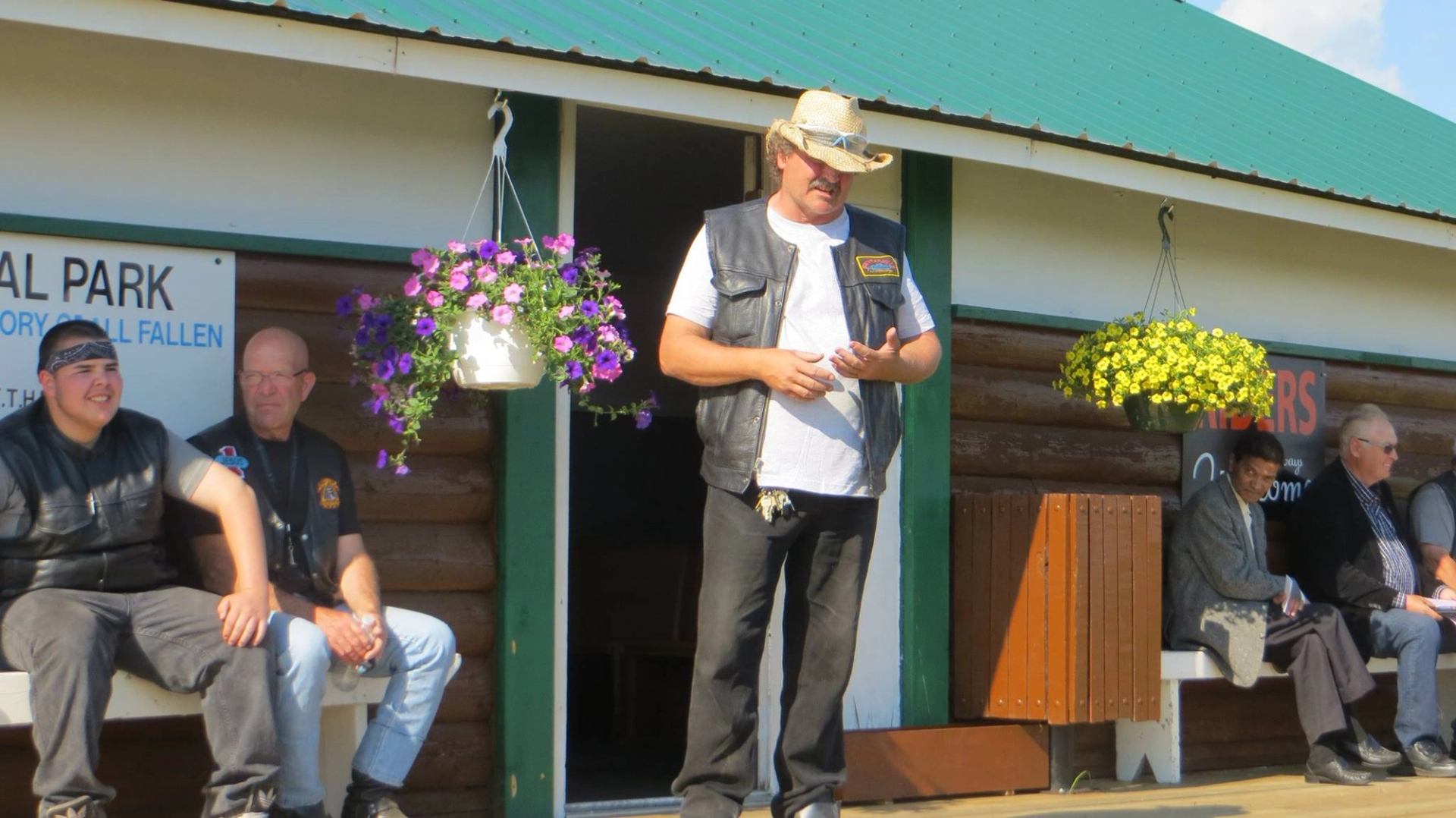 Person standing on the chapel deck with hanging flower baskets nearby