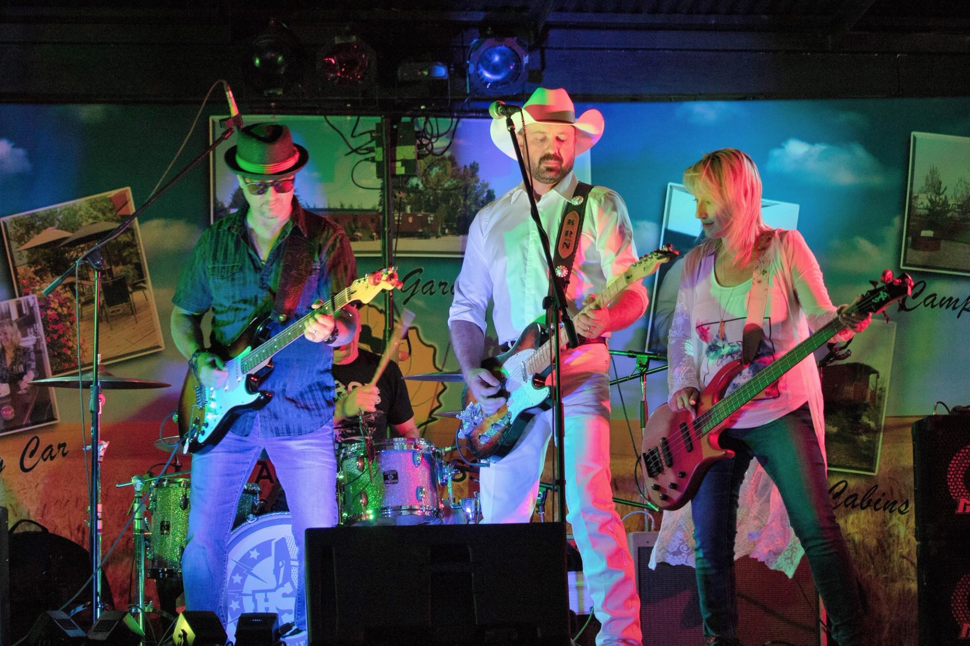Musicians perform on stage with guitars and microphones at the Southern Alberta Music Festival.