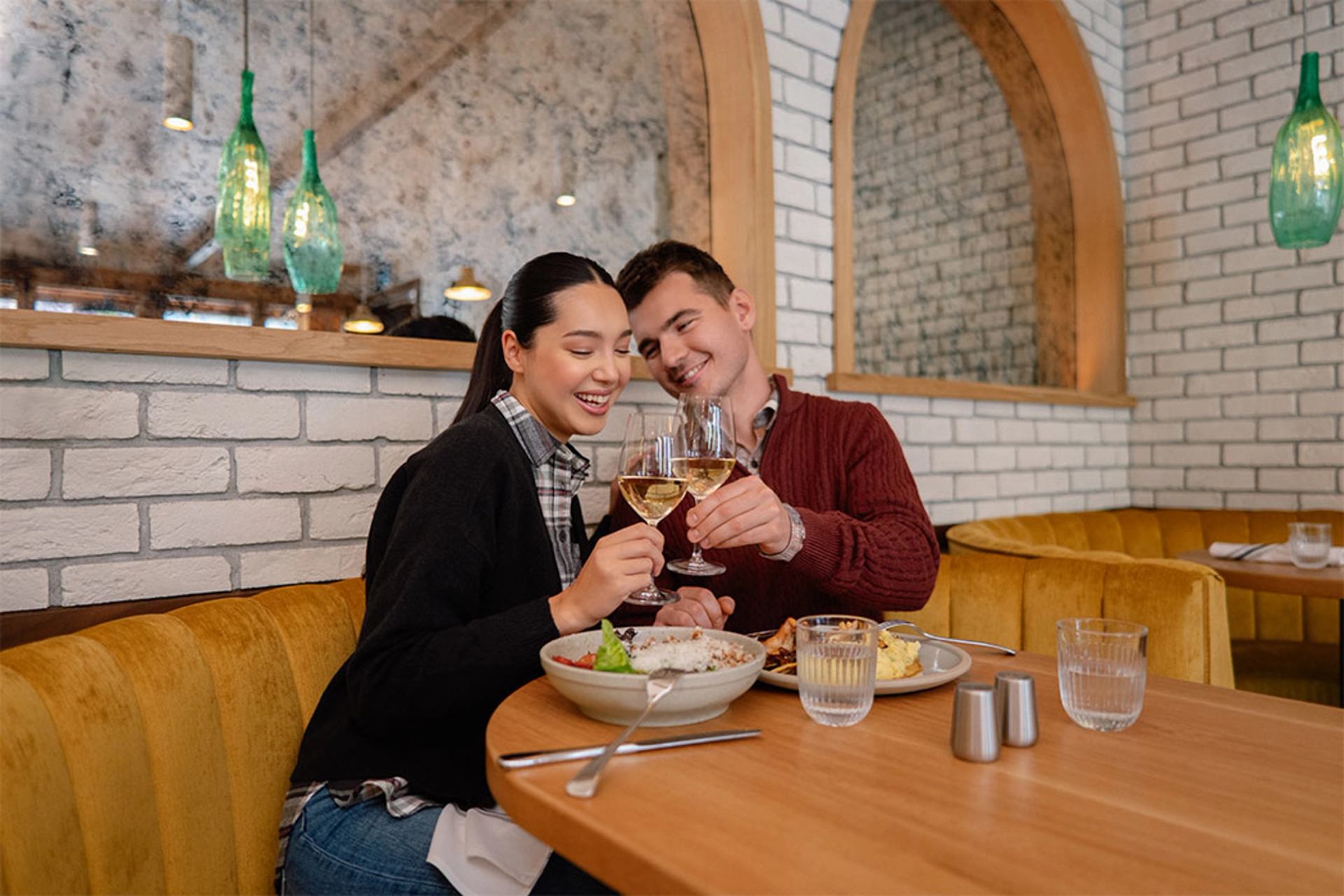 Couple clinking glasses and dining at Sudden Sally in the dining room