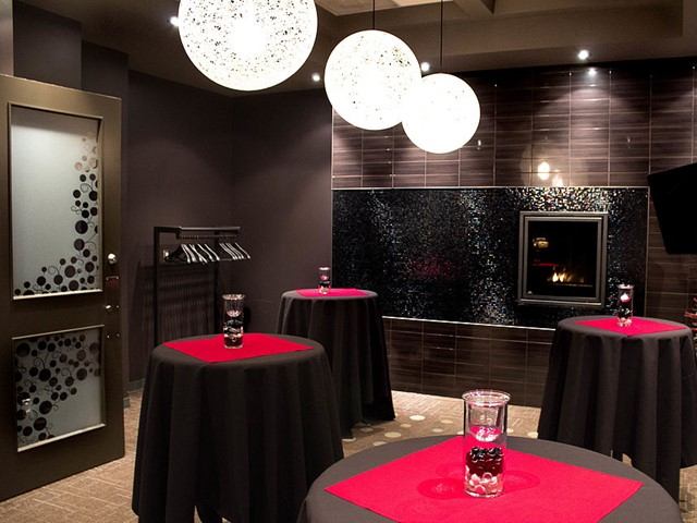 Chic room with black tables, red accents, and decorative hanging lights