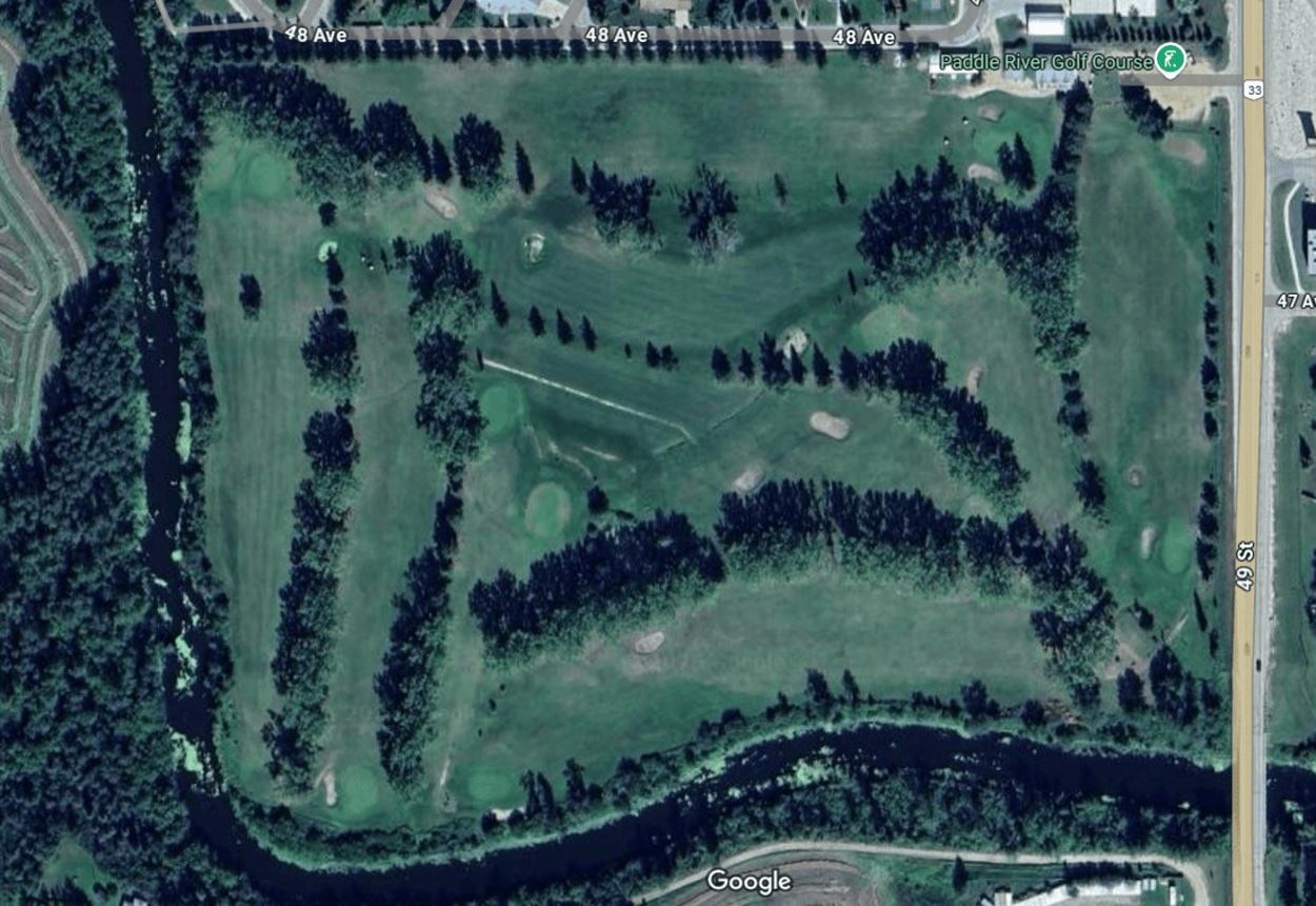 Aerial view of Paddle River Golf & Country Club with fairways, trees, and the river surrounding the course.