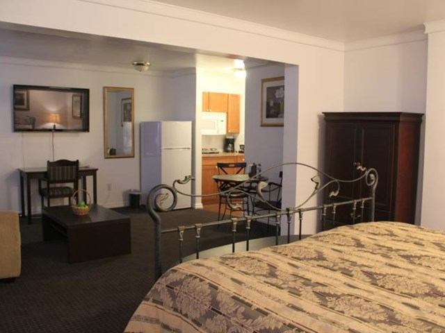 Studio-style room with kitchen, dining area, and desk at Acorn Motel.