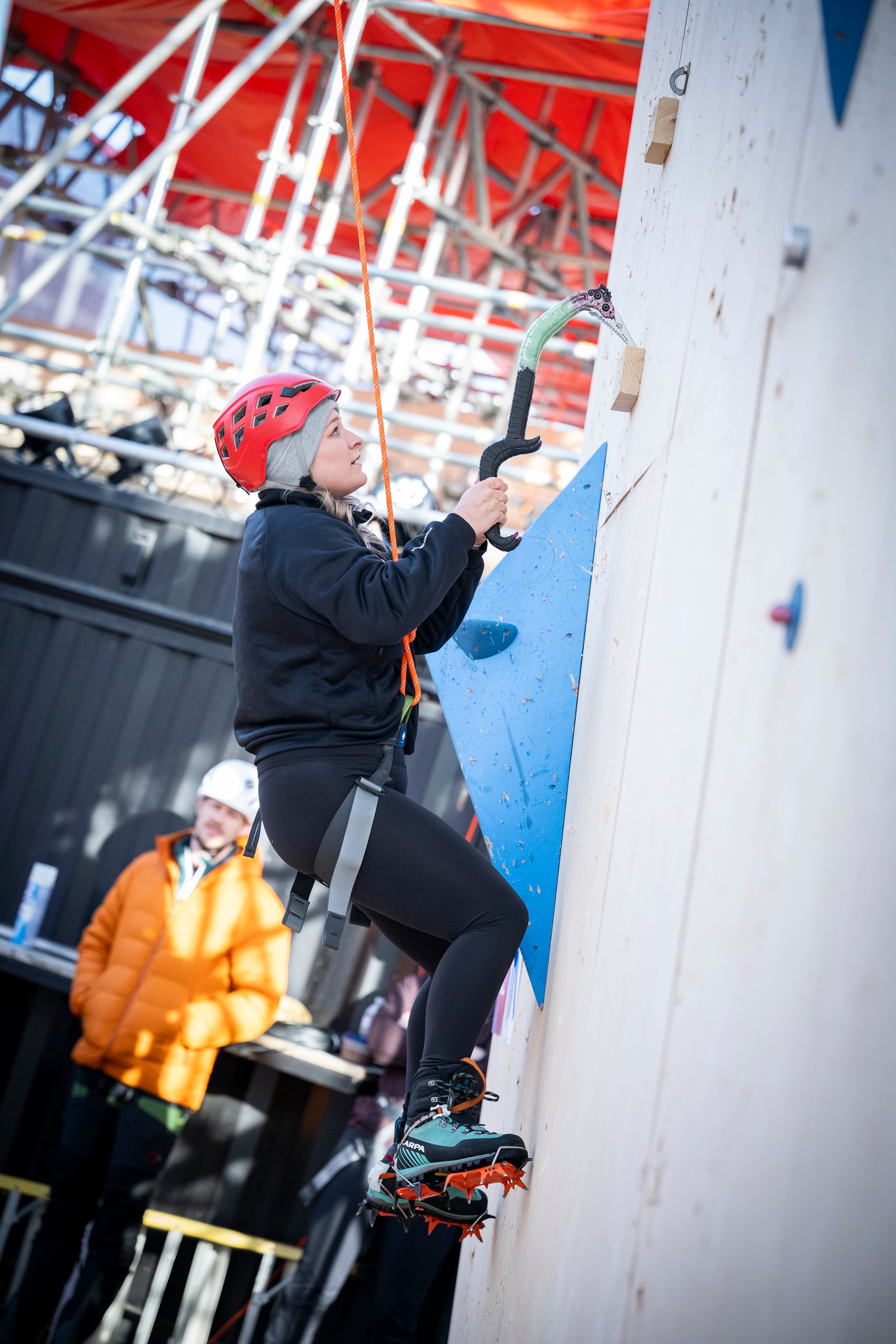 Climber using ice tools on an outdoor wall at Climb YEG.