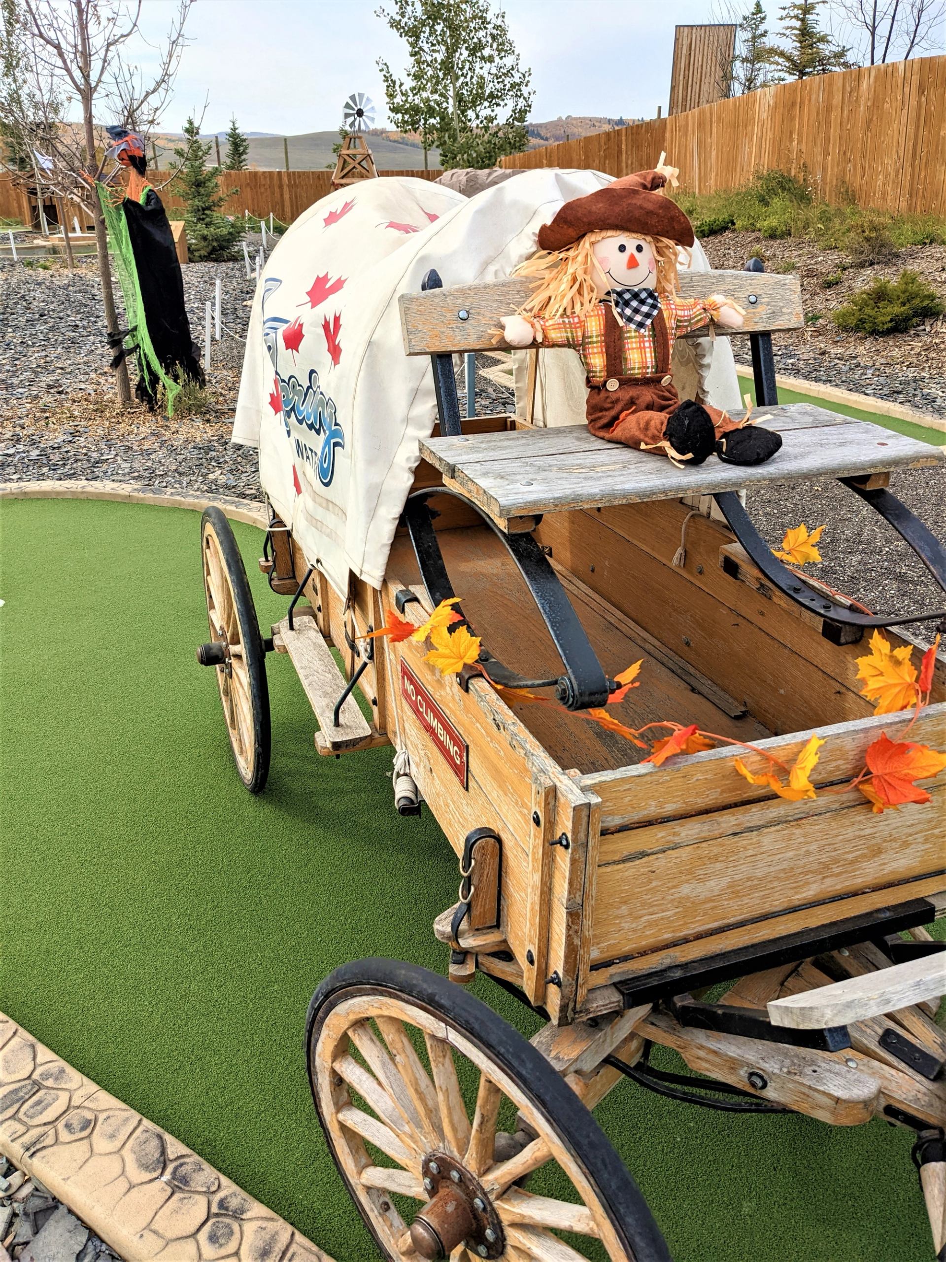 Decorated wagon with cowboy scarecrow and autumn leaves at Granary Road.