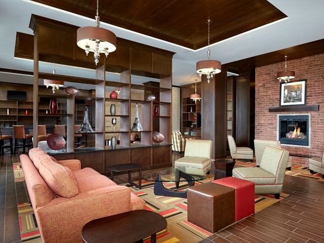 Modern hotel lobby with cozy seating and fireplace.