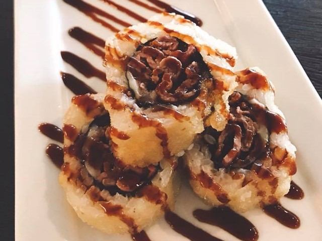 Three tempura sushi rolls with dark sauce on white plate from Kiri Japanese Cuisine.