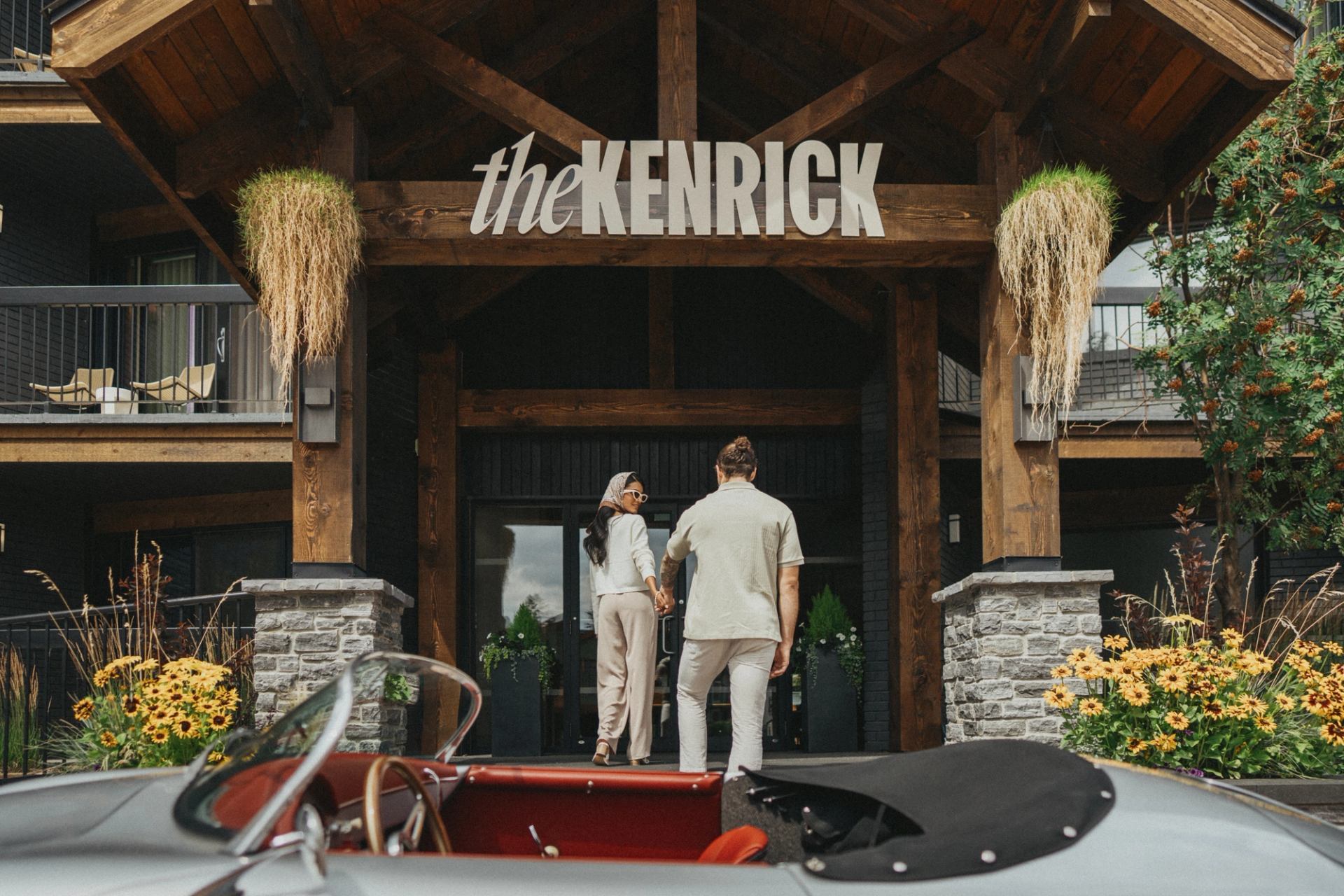 Couple walking into the main front lobby, with their vintage car parked outside.