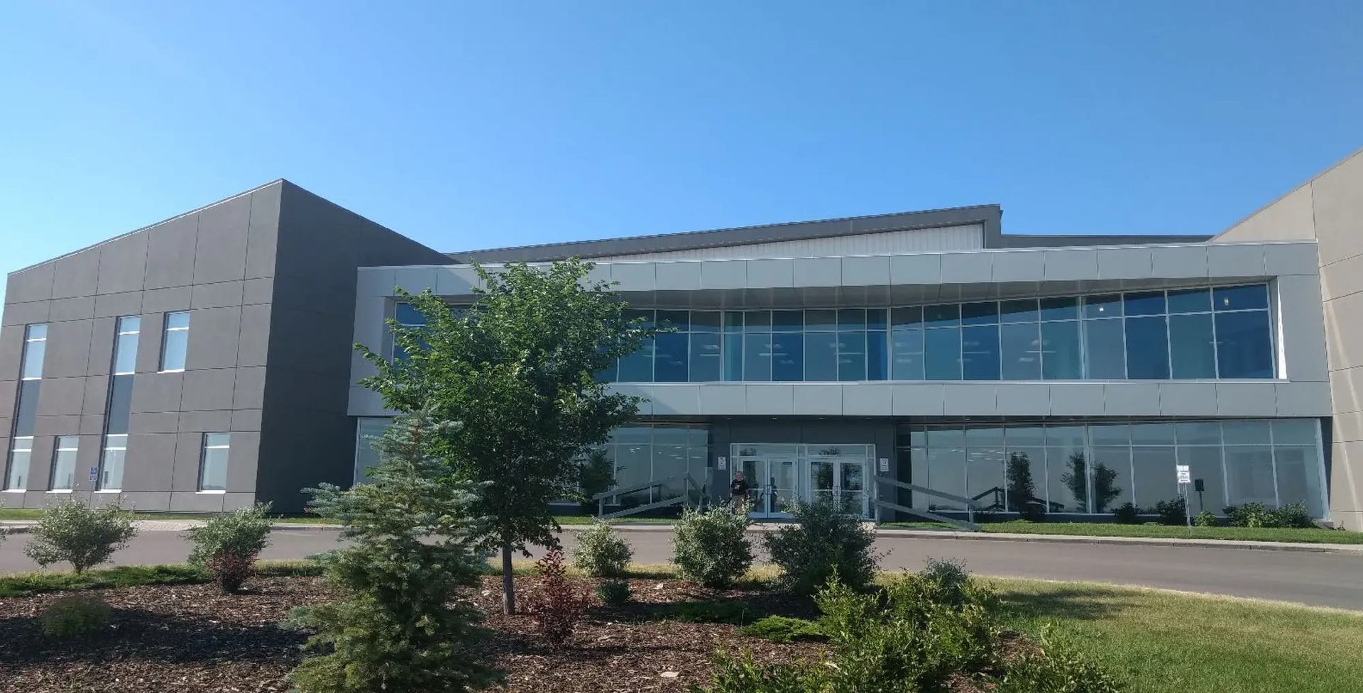 Modern two-story Regional Field House with glass entrance and landscaped surroundings.