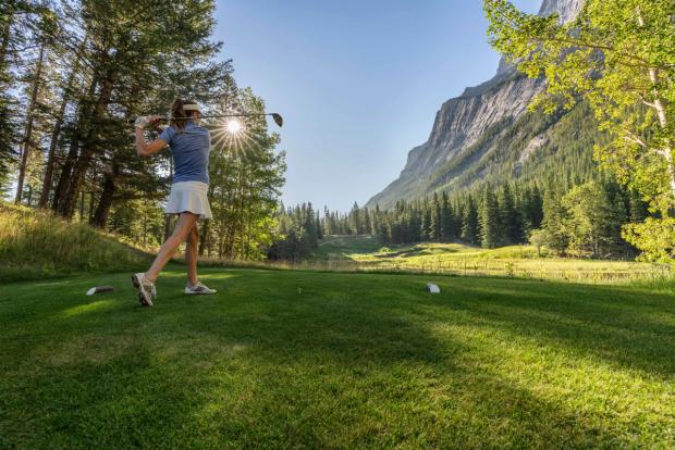 Women swinging a golf club at the Fairmont Banff Springs Golf Course.