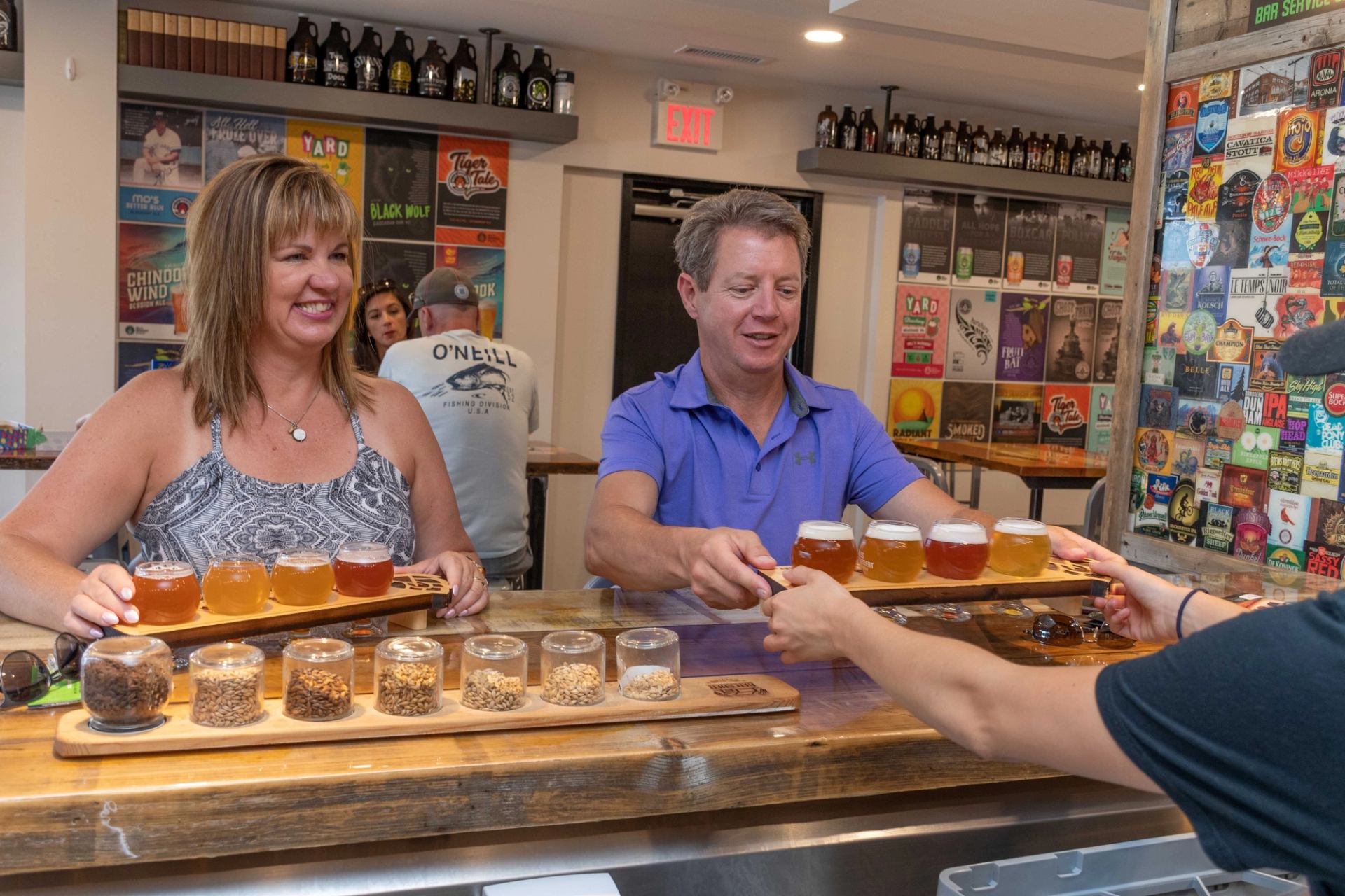 A server handing out flights of beers to customers