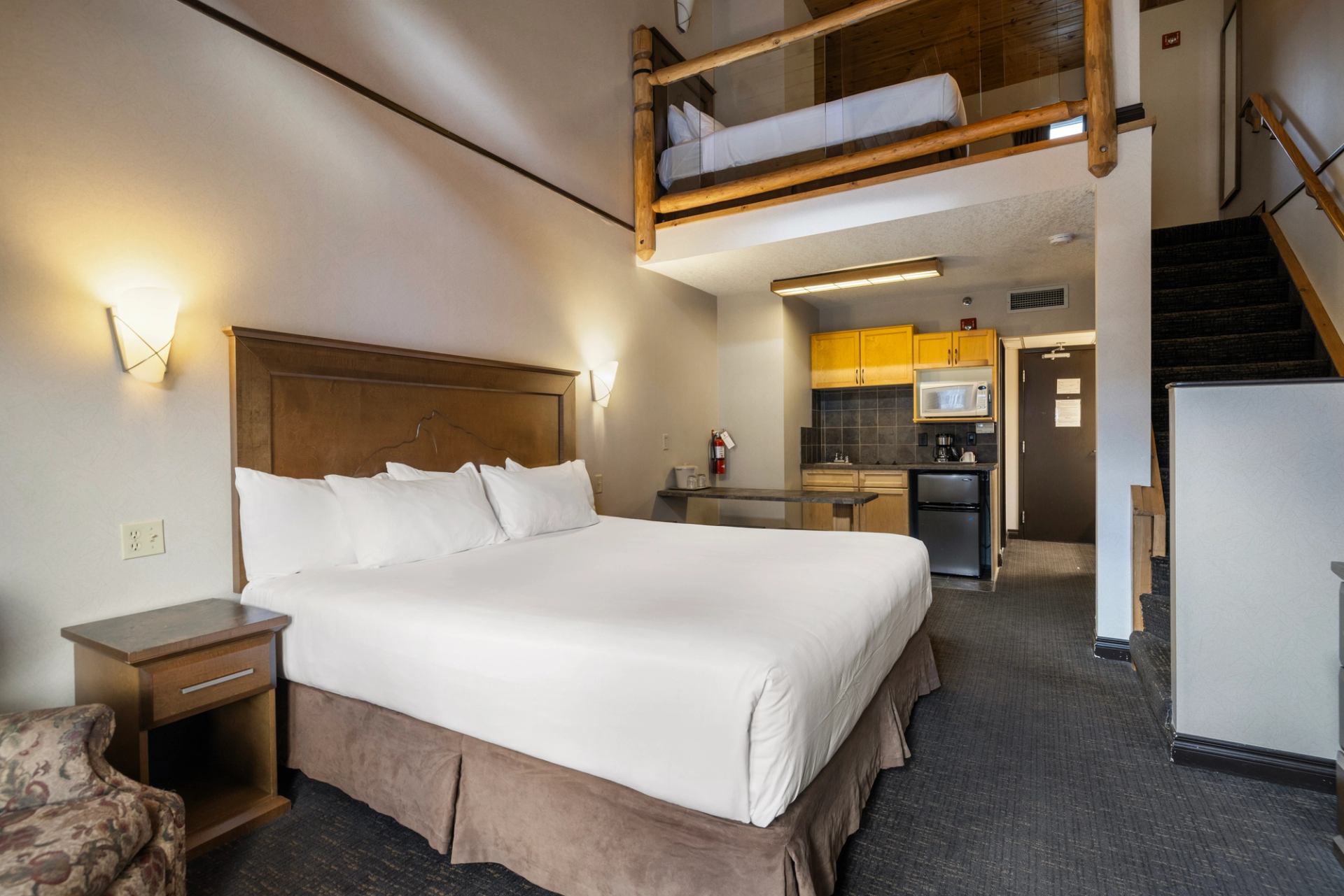Loft-style lodge room with kitchen, dining area, and two beds.