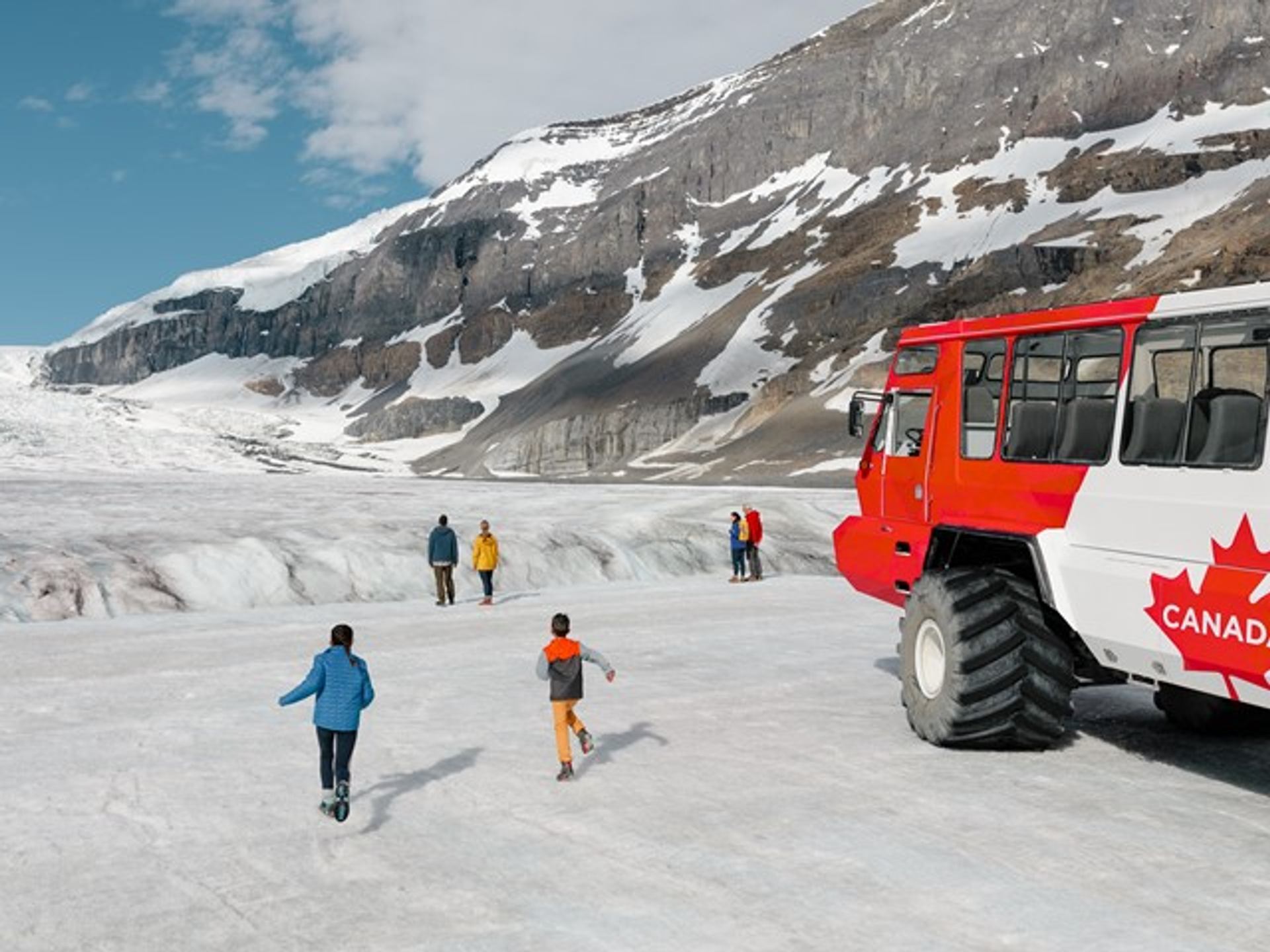 People exploring the glacier after getting off an Ice Explorer snow coach tour.