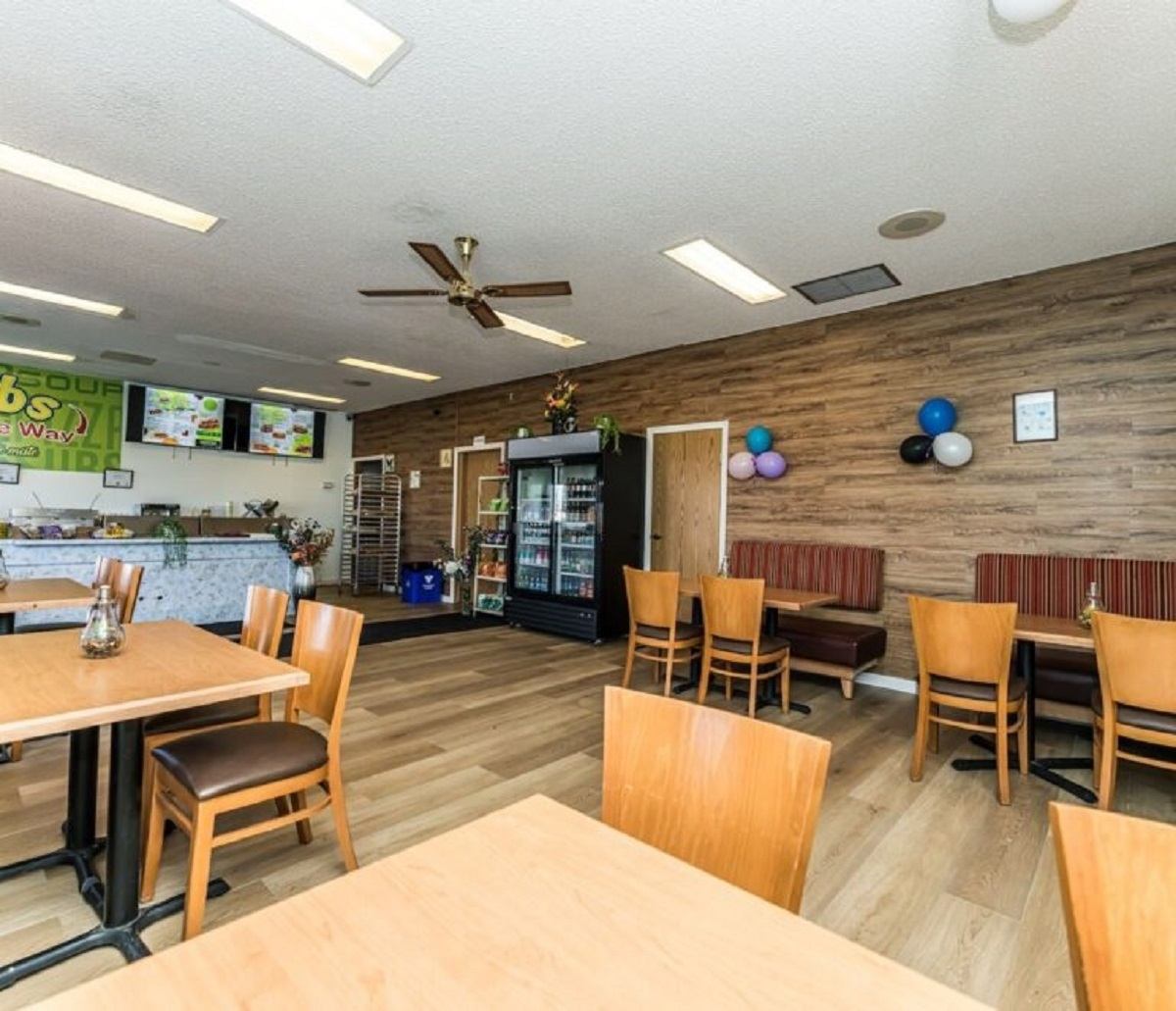 Casual dining area with wooden tables, chairs, and a counter at Big Country Inn.