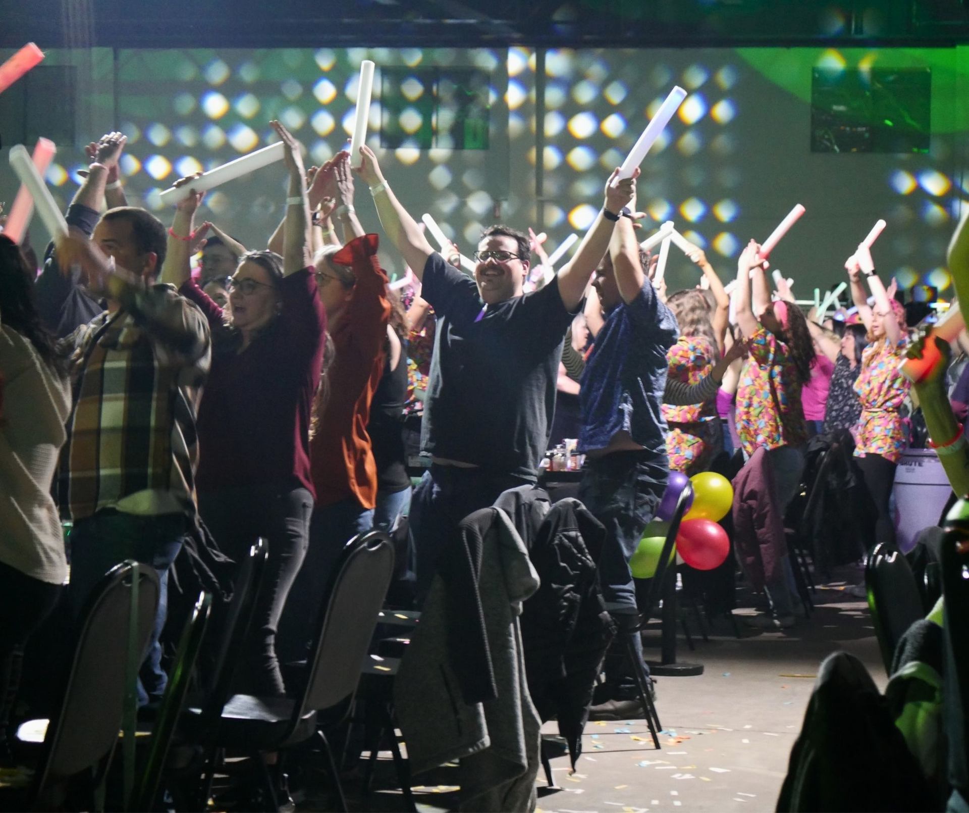 Crowd at Bingo Loco cheering with glow sticks in a high-energy party atmosphere.
