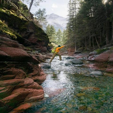 Hiker jumping over rocks at Red Rock Canyon.