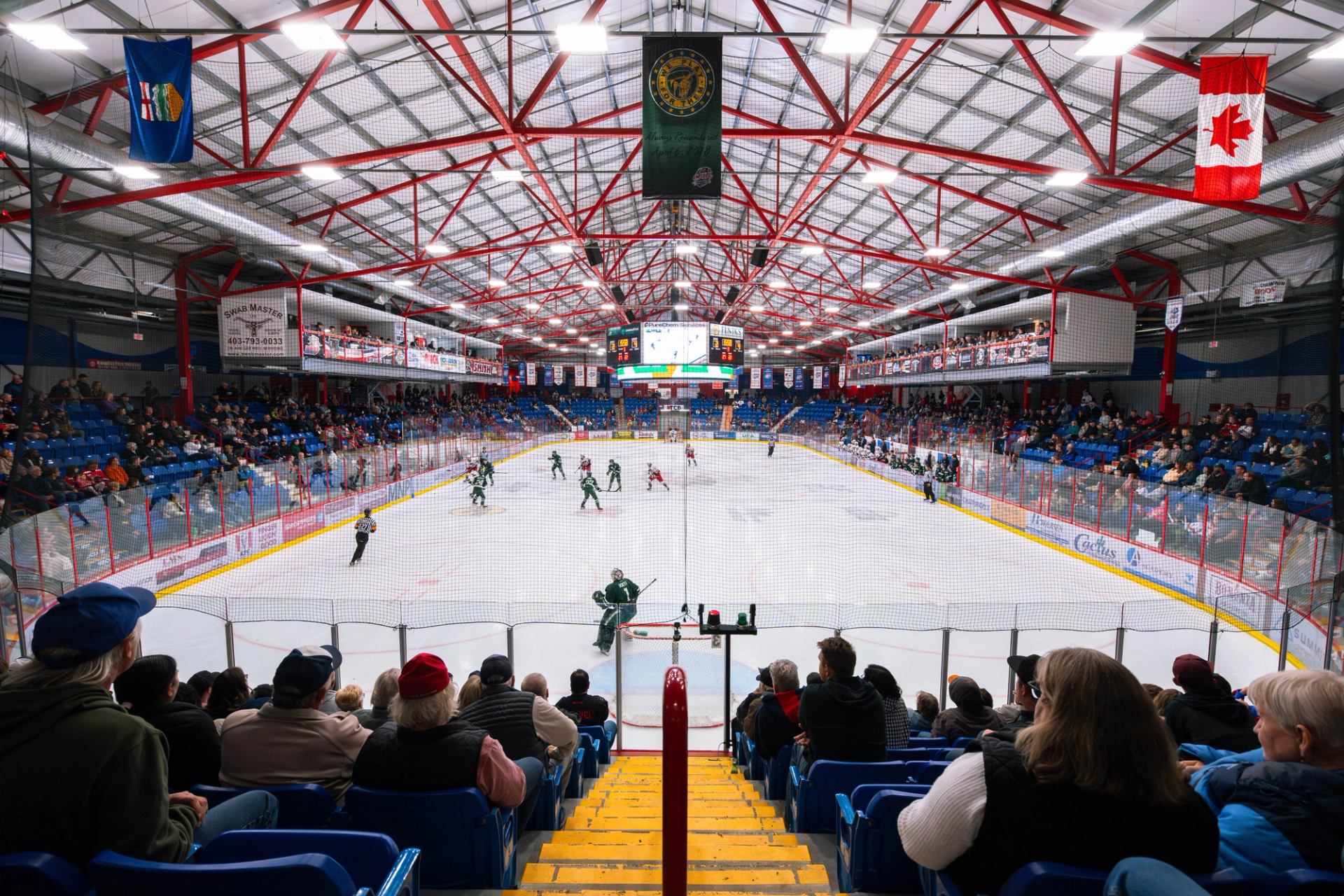 Hockey game in progress with a full crowd watching inside the arena.