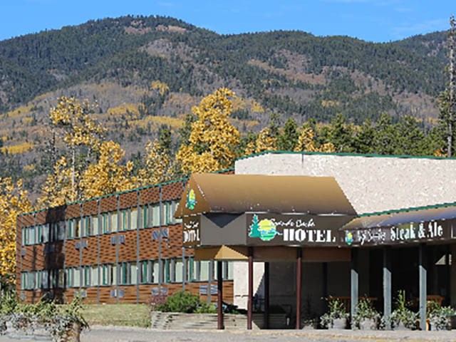 Grande Cache Hotel with mountain views and autumn trees.