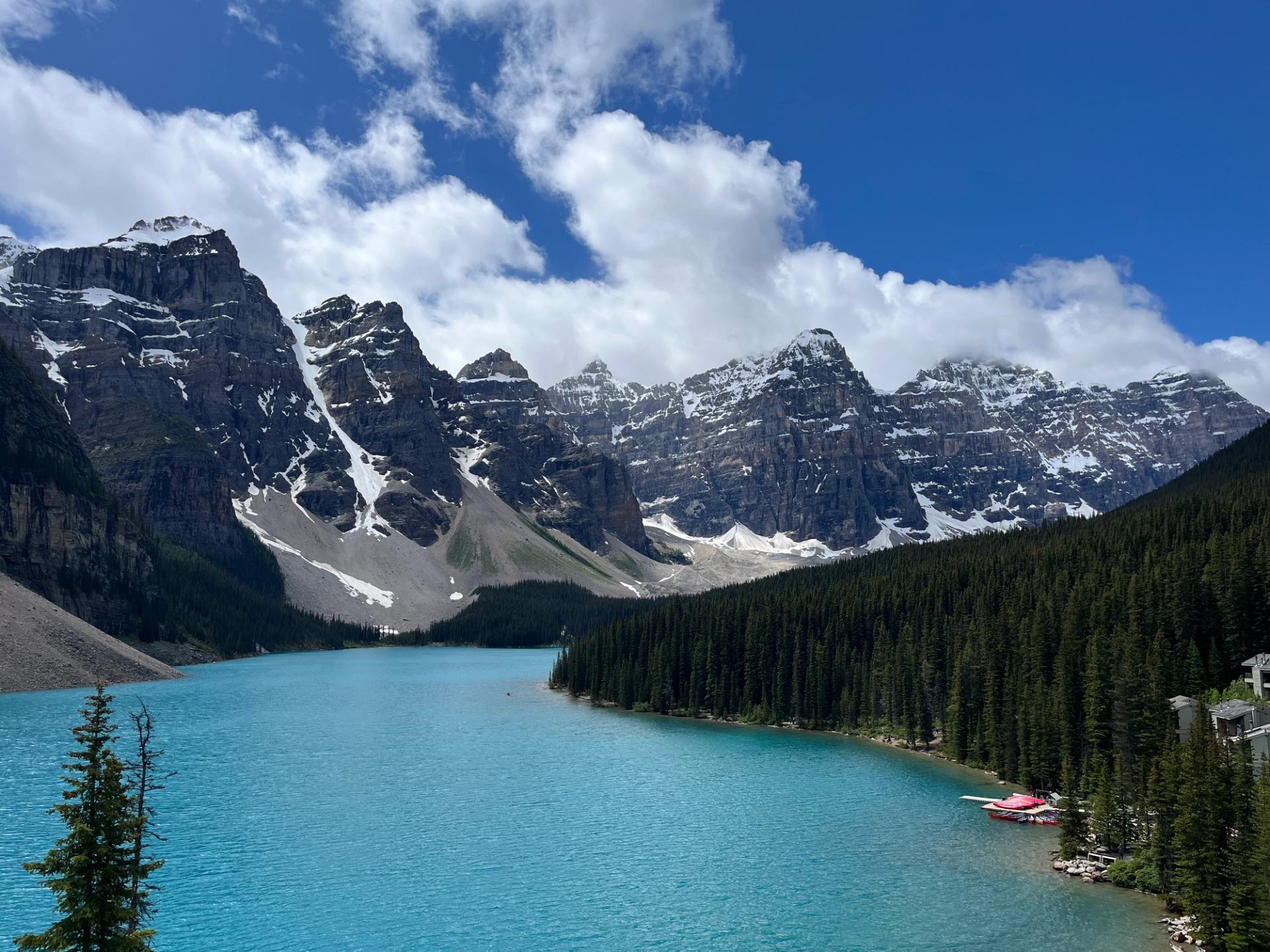 Moraine Lake with turquoise water surrounded by rugged mountain peaks.