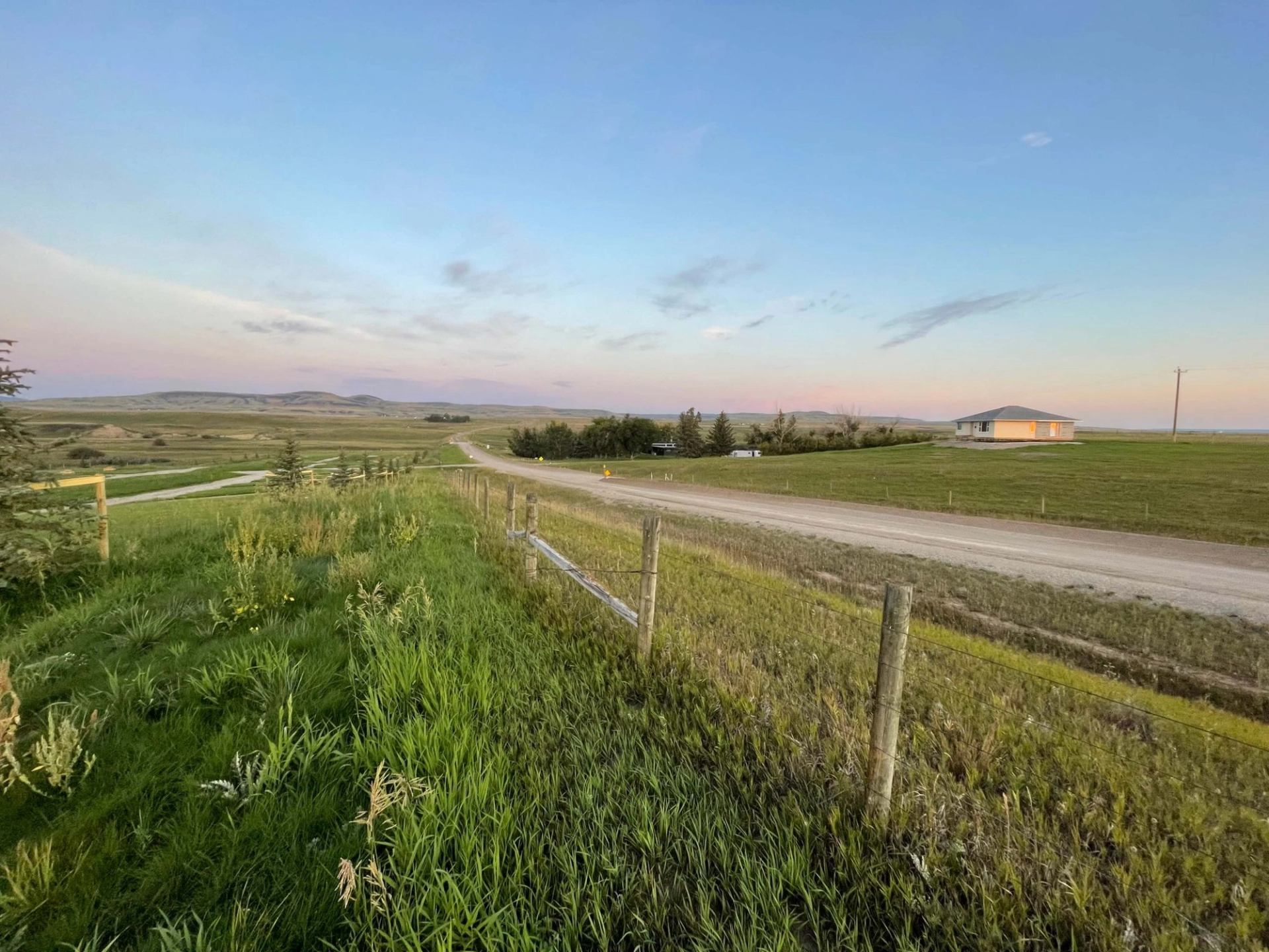 Dirt road and fence at Willow Creek Campground during sunrise or sunset.