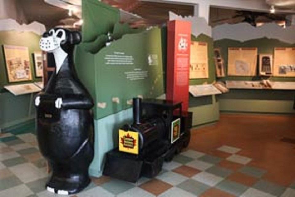 Interior of Jasper Yellowhead Museum with bear statue and train exhibit.
