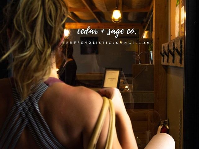 Person with yellow bag in warm, wood-accented interior at Cedar & Sage Co.