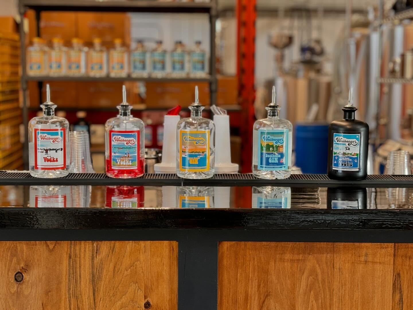 Wallbanger Distillery spirits lined up on a bar with the distillery behind.