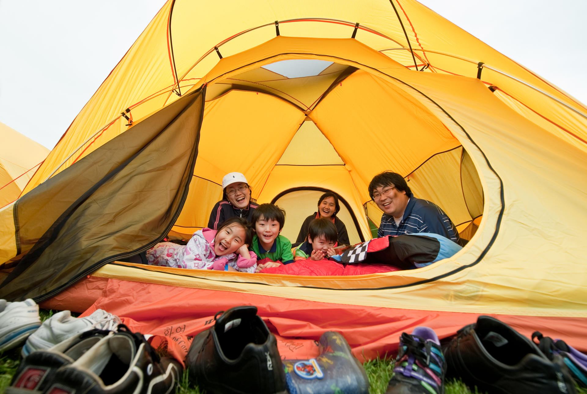 A family sitting inside a tent