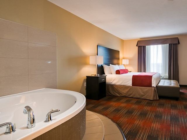 Hotel room with bed and in-room bathtub at Best Western Plus Red Deer Inn & Suites.