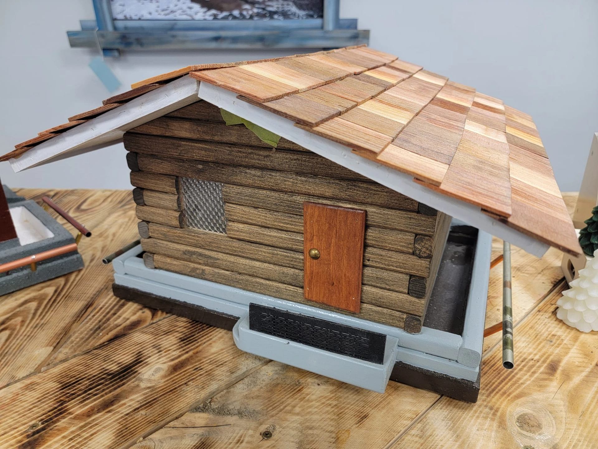 A log cabin bird feeder with a cedar roof.